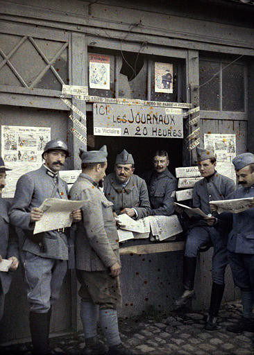 Verkauf von Zeitungen an einem Marktstand, Rexpoede (Nord), Autochrom von Paul Castelnau, 6. September 1917, Ministère de la Culture (Frankreich) – Médiathèque de l’architecture et du patrimoine.