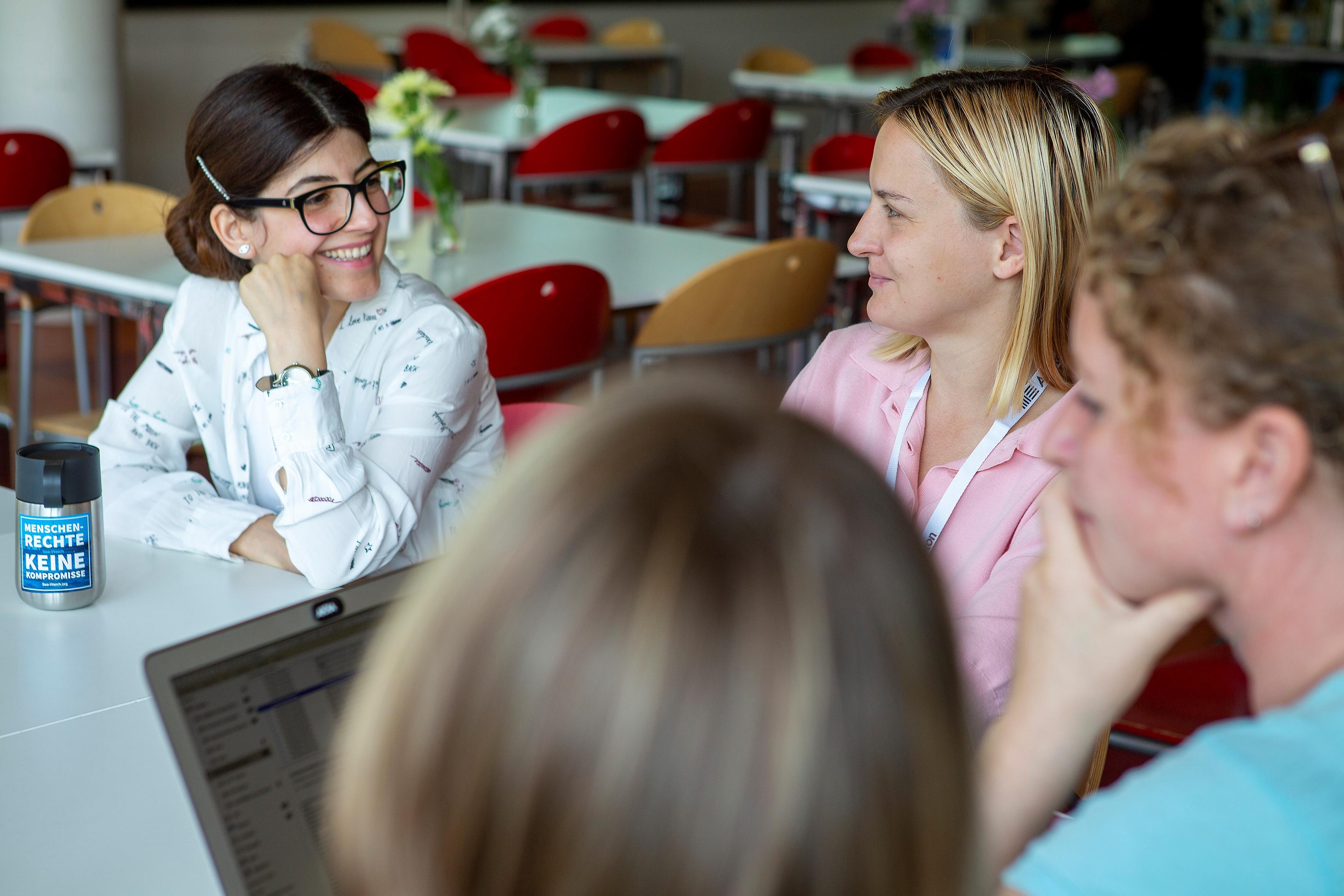 Vier Frauen sitzen an einem Tisch.